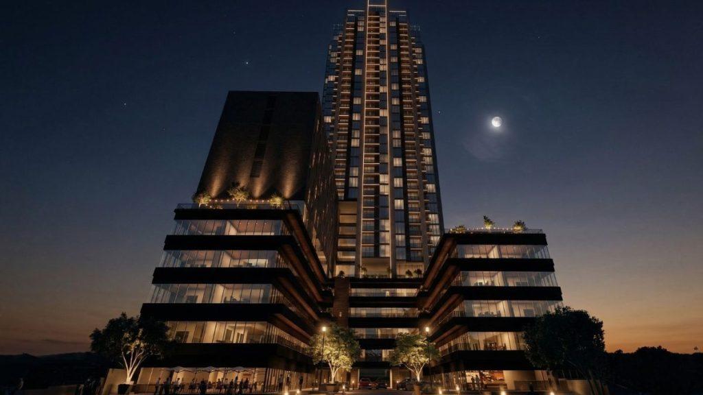 Night view of a futuristic multi-tiered glass building with illuminated terraces and a visible crescent moon above.