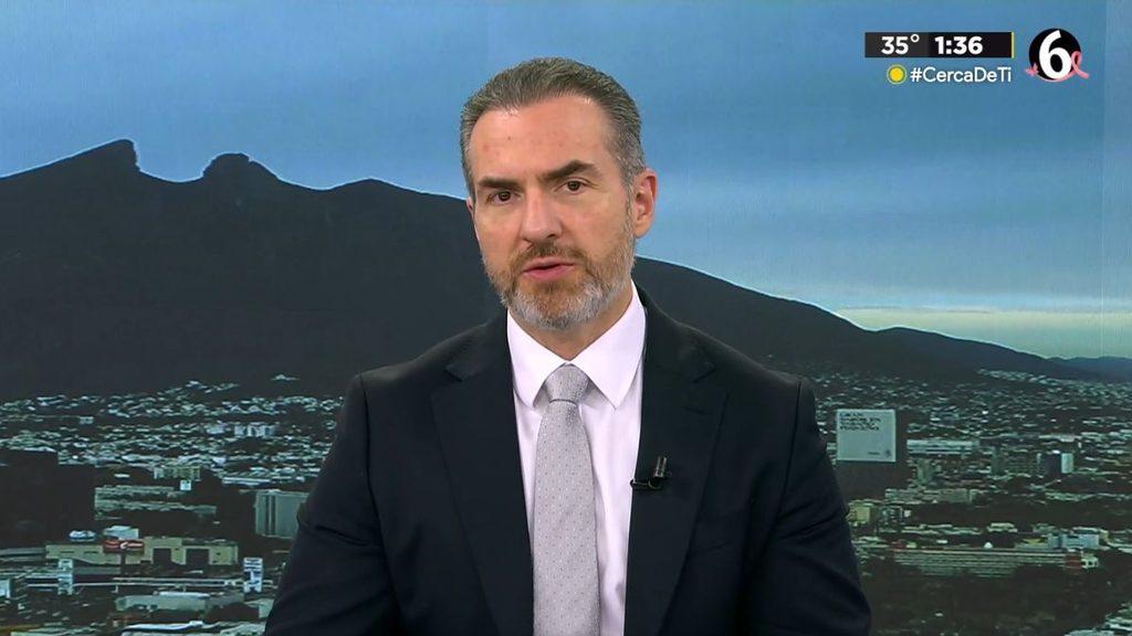 hechos-am-adrian-de-la-garza-alianza-pan-y-prijpg - HECHOS AM Male news anchor in a dark suit and light gray tie delivers a broadcast against a city skyline backdrop. A small microphone is clipped to his lapel.